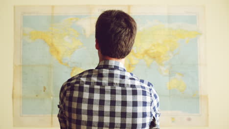 Young-tourist-man-looking-at-world-map
